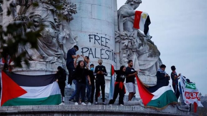 
 Para pengunjuk rasa memegang bendera Palestina selama demonstrasi tidak sah untuk mendukung warga Palestina, sebagai bagian dari konflik yang sedang berlangsung antara Israel dan kelompok Islam Palestina Hamas, di Place de la Republique di Paris ketika Menteri Dalam Negeri Prancis Gerald Darmanin memerintahkan pelarangan sistematis demonstrasi pro-Palestina dan penangkapan peserta di Prancis, 12 Oktober 2023. REUTERS/Sarah Meyssonnier